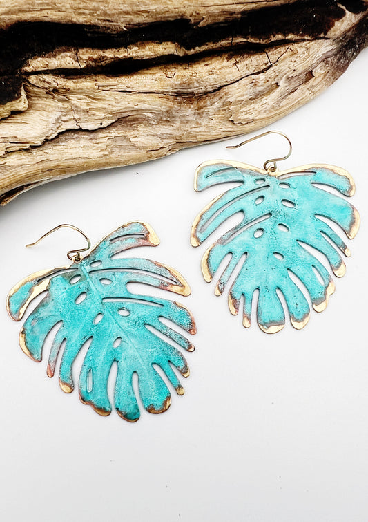 Vivacious modern boho statement jewelry – handcrafted blue patina monstera leaf earrings, a bold and artistic design from Real to the Roots Jewelry. 