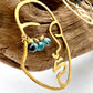 up close image of Hammered brass face earrings with blue wired beaded lashes in customizable colors. 14k gold-filled ear wires, lightweight and full of personality