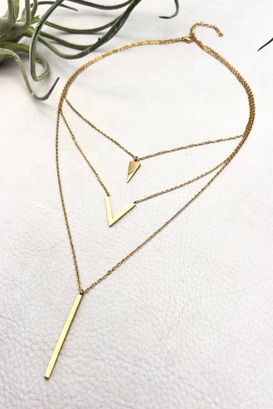 golden layered necklace with triangle, V shape and spike pendants