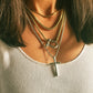 Woman wearing chunky necklaces with carabiner and Cross