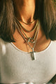 Woman wearing chunky necklaces with carabiner and Cross