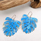 Vivacious modern boho statement jewelry – handcrafted blue patina monstera leaf earrings, a bold and artistic design from Real to the Roots Jewelry. 