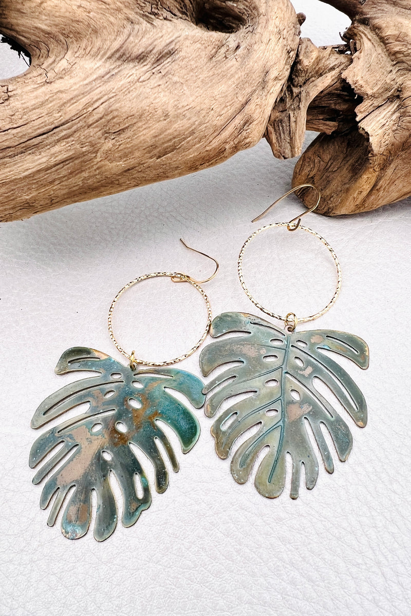 Vivacious modern boho statement jewelry – handcrafted blue patina monstera leaf earrings, a bold and artistic design from Real to the Roots Jewelry. 