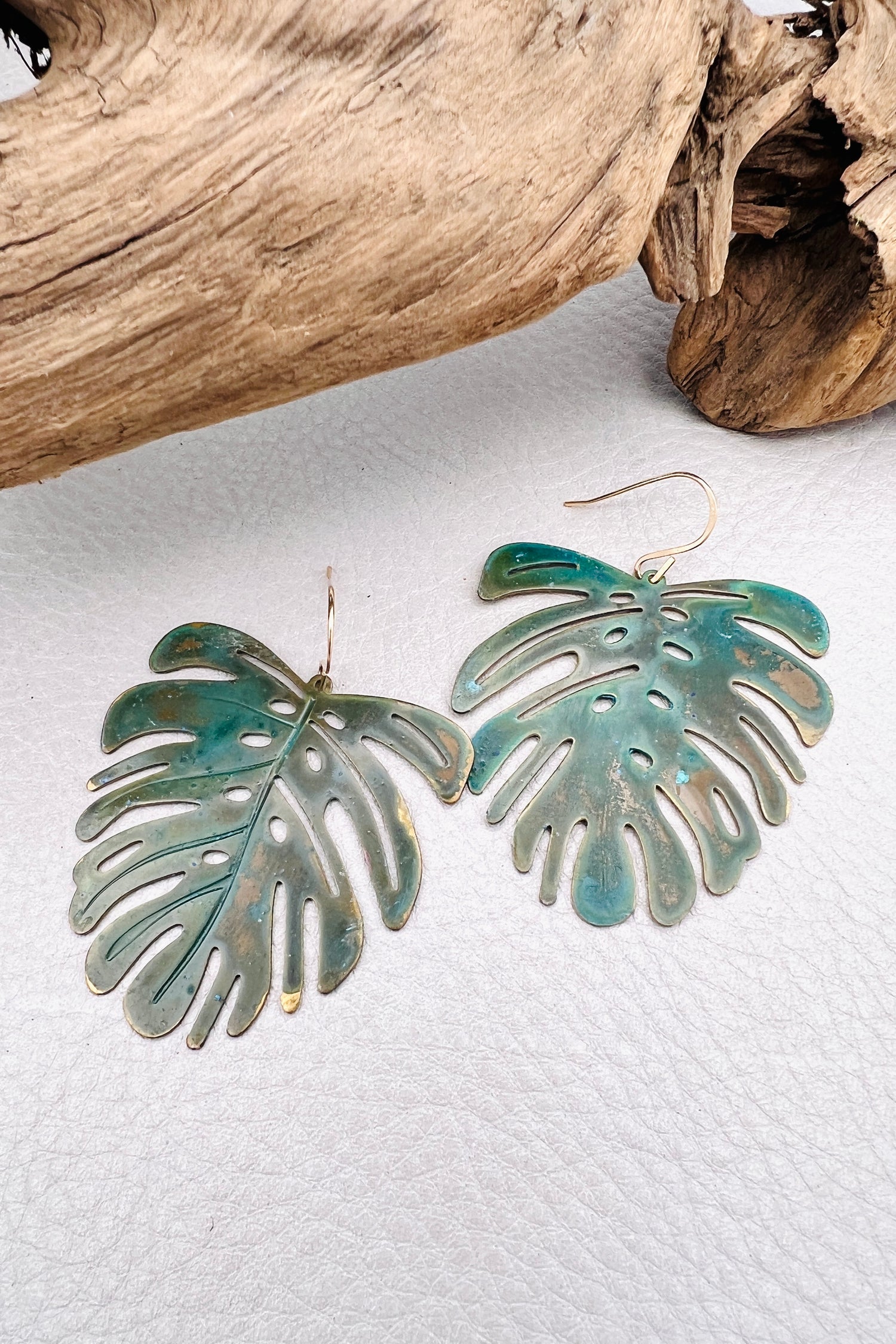 Vivacious modern boho statement jewelry – handcrafted blue patina monstera leaf earrings, a bold and artistic design from Real to the Roots Jewelry. 