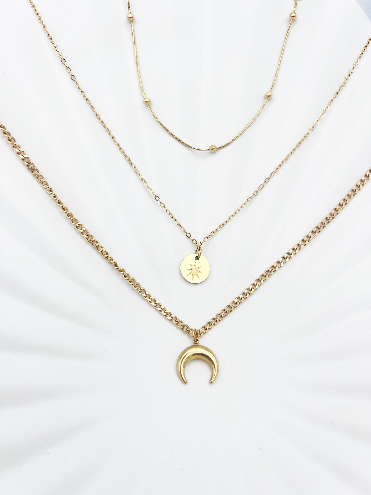 Triple-layered 14k gold-plated stainless steel necklace with a crescent moon, sun coin, and satellite chain. Waterproof and tarnish-resistant.