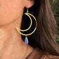 woman wearing a crescent moon earring with a wired gem
